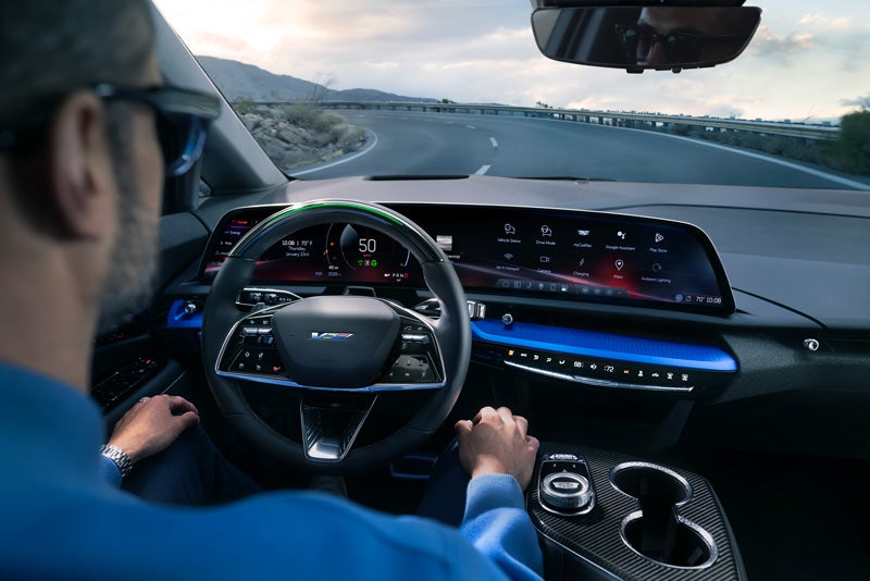 Front View of the 2026 OPTIQ-V Driving Through the Dusk Utilizing its Headlights | Scott Cadillac in Allentown PA