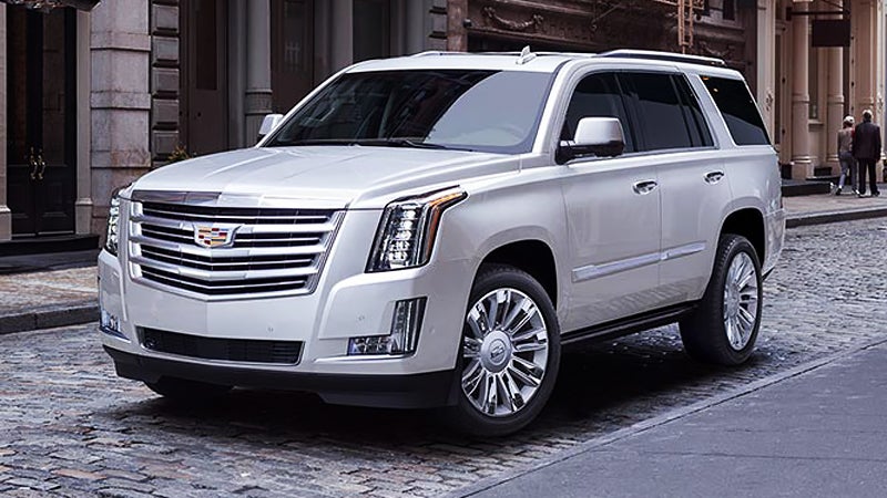 A white Cadillac SUV parked on the side of a street