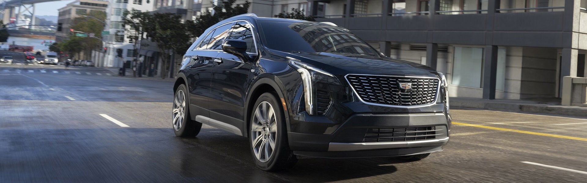 A 2020 Cadillac XT4 driving along a bustling city street