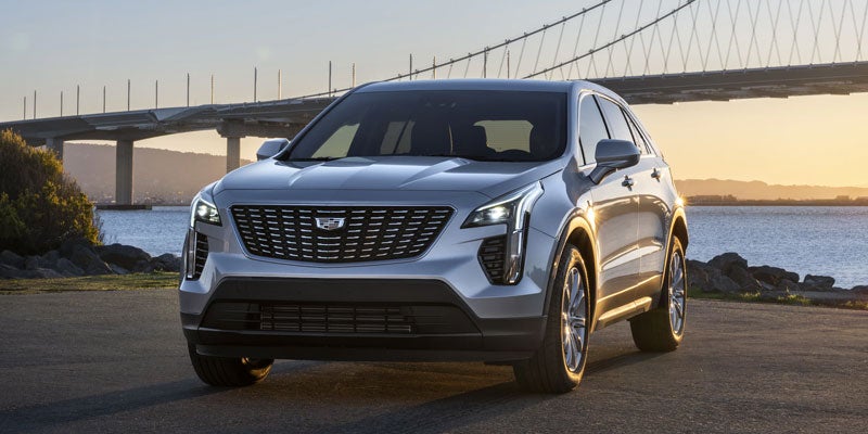 A 2021 Cadillac XT4 parked in front of a bridge