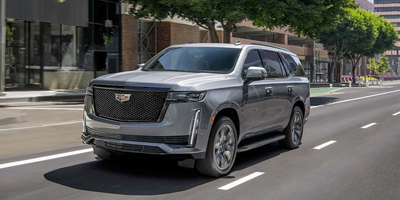 A 2020 Cadillac Escalade is displayed in a dimly lit environment